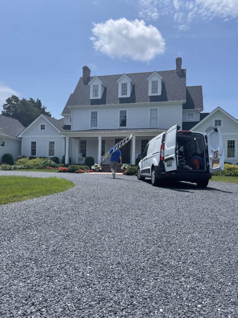 Trained professionals performing residential house washing with safety standards