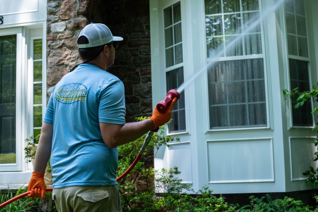 Residential house exterior being soft-washed