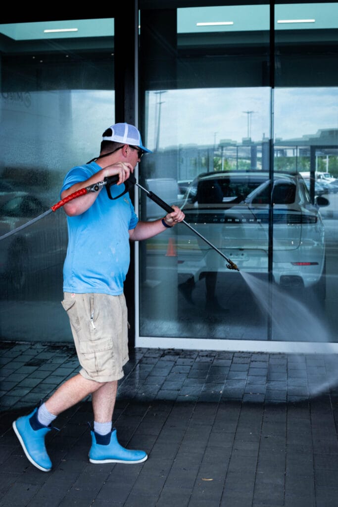 Commercial building exterior being cleaned with professional power washing equipment.