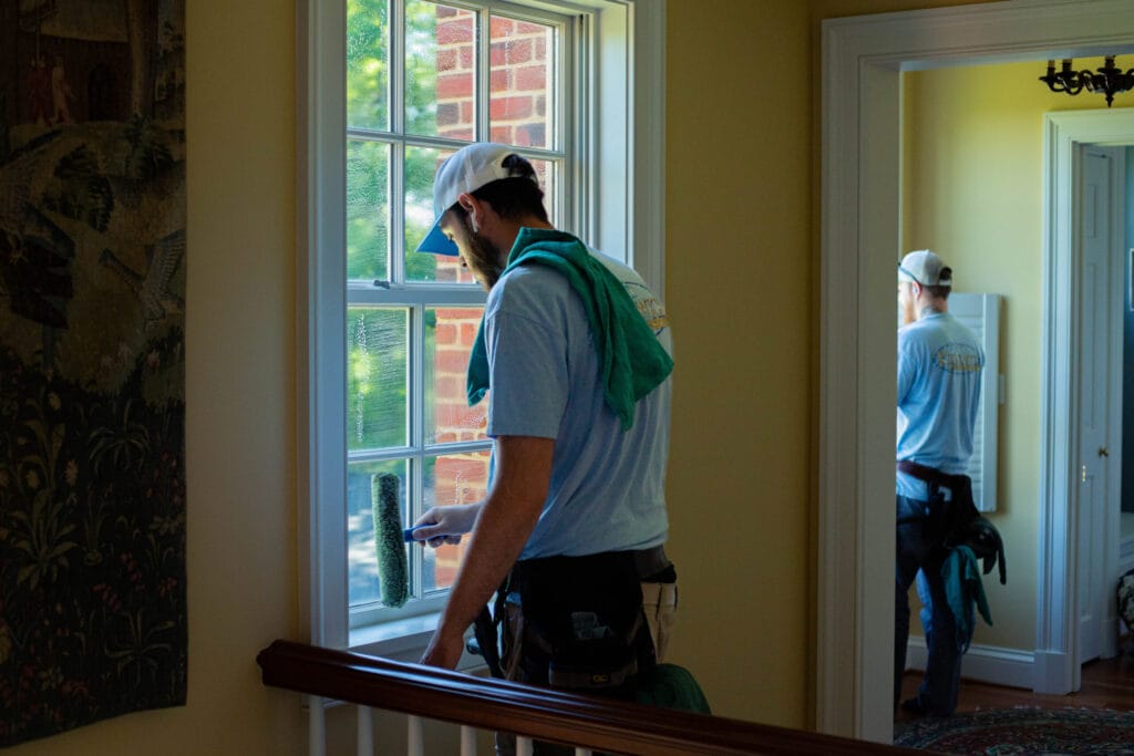 Keenwick team performing residential window cleaning on a modern home, showcasing streak-free, sparkling windows.