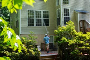 Soft washing service in progress, removing dirt and grime from home exterior.