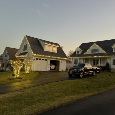 Coach lights and exterior garage fixtures on residential Annapolis Maryland home at dusk