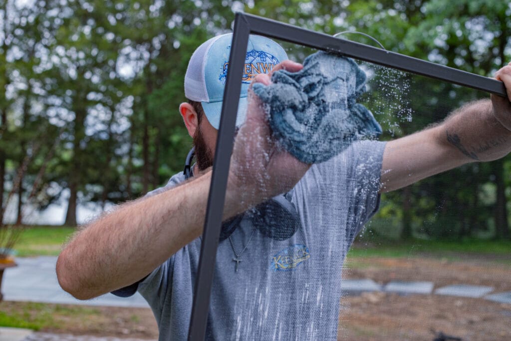 Keenwick technician hand-cleaning a removable window screen at Annapolis Maryland home